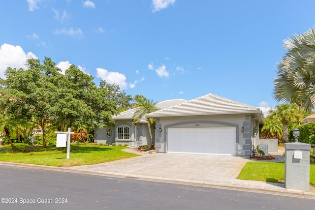 view of front of property with a front yard and a garage