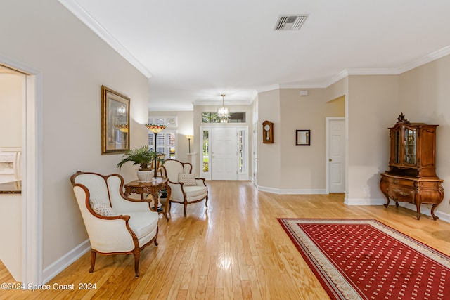 entryway featuring wood-type flooring, crown molding, and a notable chandelier