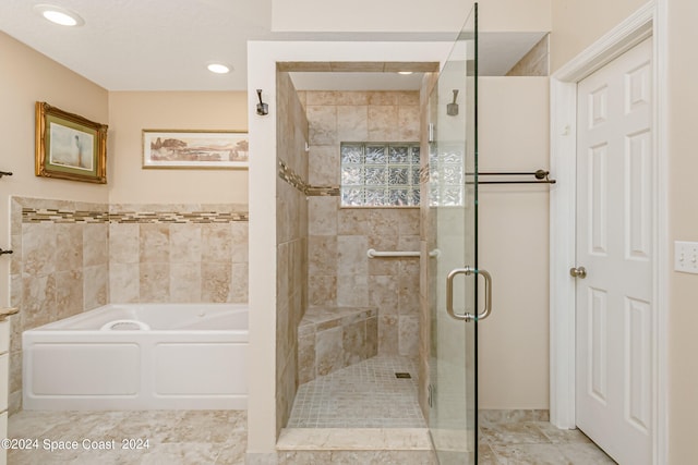 bathroom featuring shower with separate bathtub and tile walls