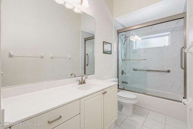 full bathroom with tile patterned flooring, combined bath / shower with glass door, vanity, and toilet