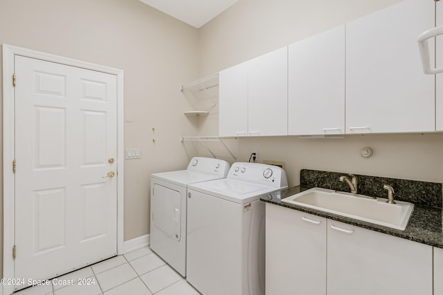 clothes washing area with light tile patterned floors, sink, independent washer and dryer, and cabinets