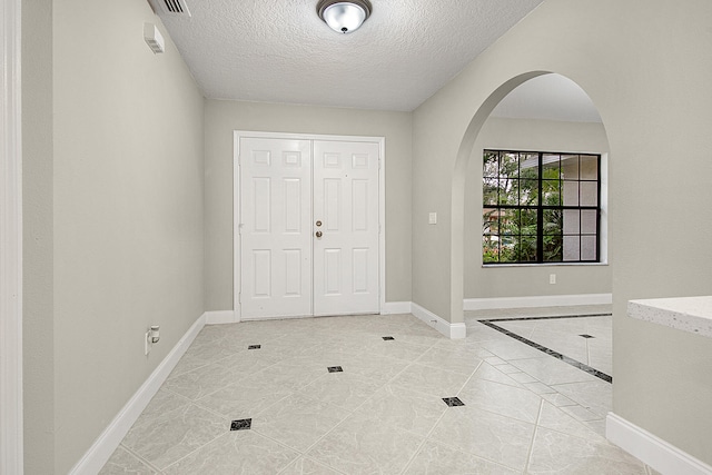 tiled foyer featuring a textured ceiling