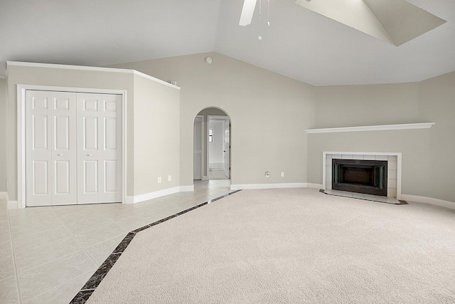 unfurnished living room featuring light carpet, lofted ceiling, ceiling fan, and a fireplace