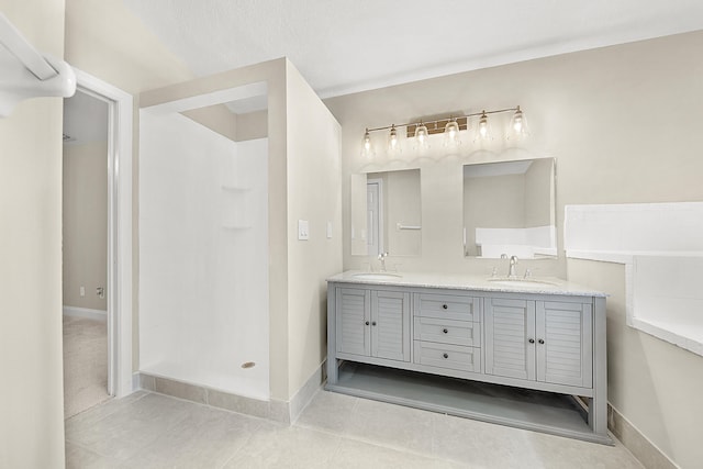 bathroom with a shower, vanity, and tile patterned floors