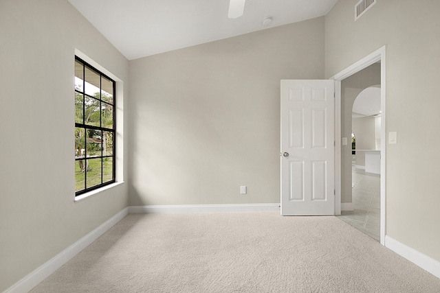 carpeted spare room with lofted ceiling