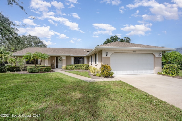 single story home featuring a garage and a front lawn