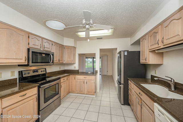 kitchen featuring appliances with stainless steel finishes, sink, a textured ceiling, and light brown cabinets