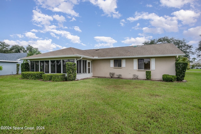 back of property with a lawn and a sunroom