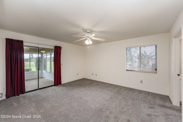 carpeted spare room with ceiling fan and a textured ceiling