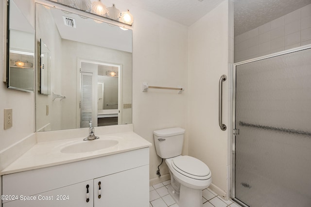 bathroom with vanity, a shower with door, tile patterned flooring, and a textured ceiling