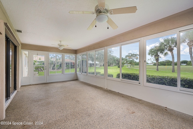 unfurnished sunroom featuring ceiling fan