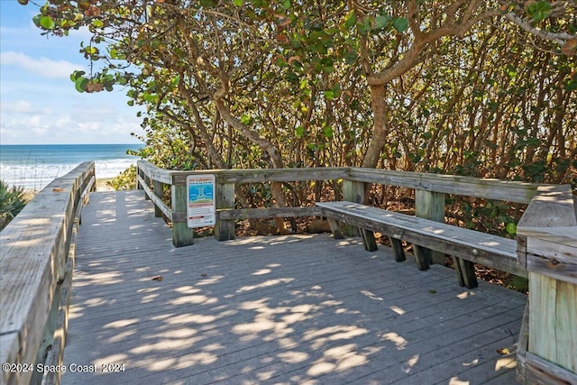 view of dock with a view of the beach and a deck with water view