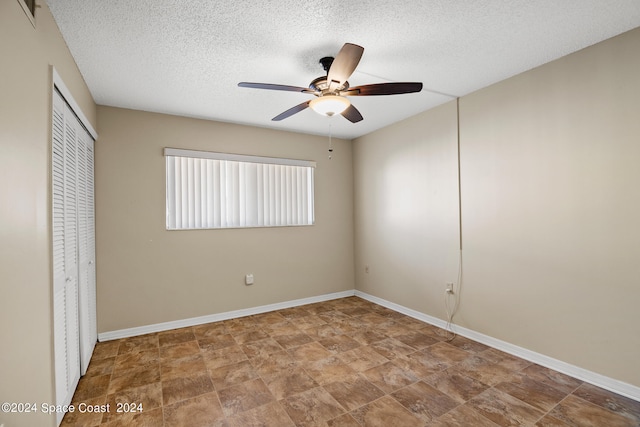 unfurnished bedroom with ceiling fan, a closet, and a textured ceiling