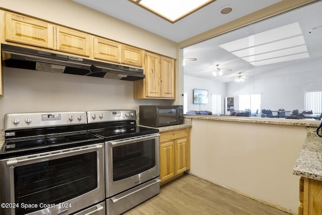 kitchen with light wood-type flooring, a healthy amount of sunlight, and electric stove