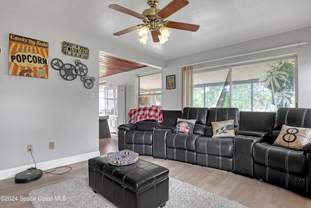 living room with a textured ceiling, hardwood / wood-style flooring, and ceiling fan