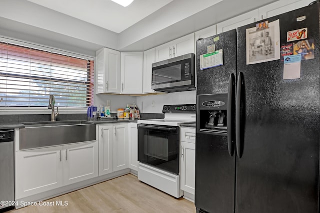 kitchen featuring white cabinetry, sink, light hardwood / wood-style floors, and appliances with stainless steel finishes