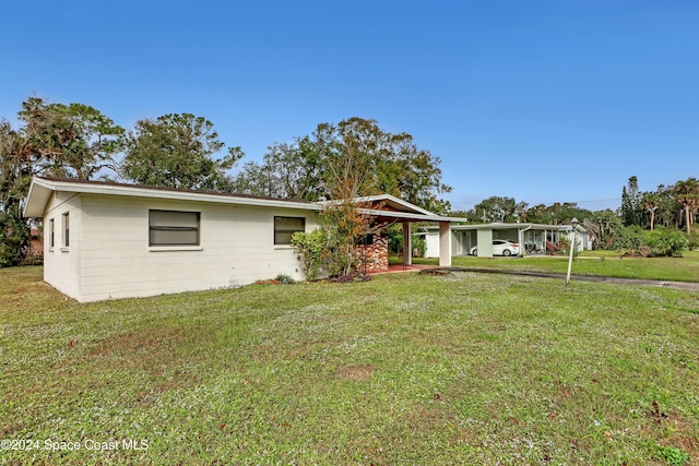 ranch-style home featuring a front lawn and a carport