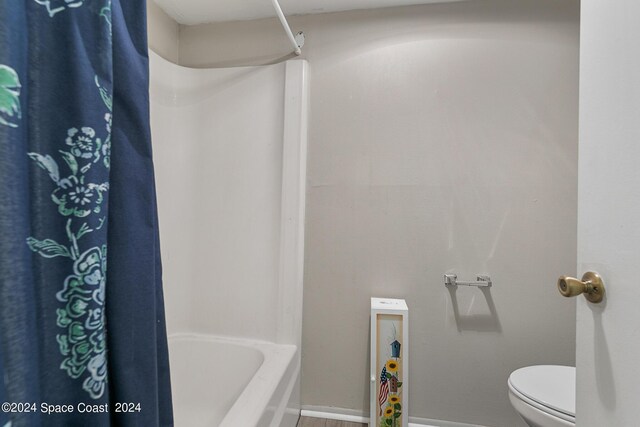 bathroom with shower / tub combo and toilet