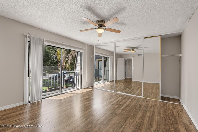 unfurnished bedroom with wood-type flooring, a textured ceiling, a closet, and access to outside