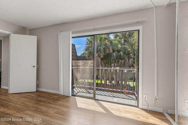 spare room featuring a textured ceiling and hardwood / wood-style flooring