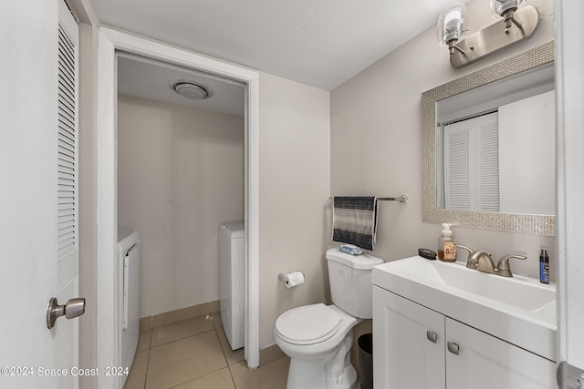 bathroom with separate washer and dryer, vanity, toilet, and tile patterned flooring