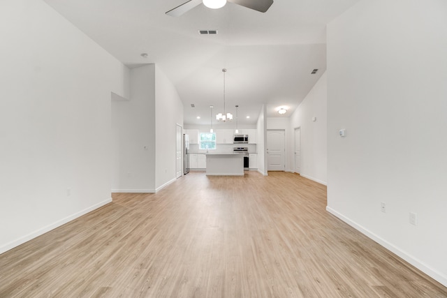 unfurnished living room featuring ceiling fan with notable chandelier, vaulted ceiling, and light hardwood / wood-style floors