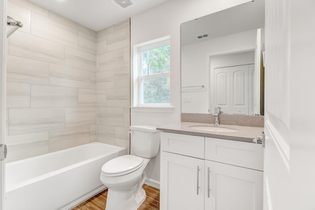 full bathroom with hardwood / wood-style floors, vanity, toilet, and tiled shower / bath combo