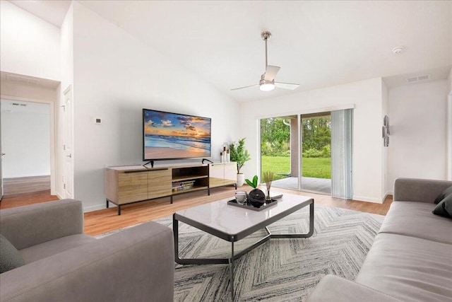 living room with high vaulted ceiling, ceiling fan, and light hardwood / wood-style flooring