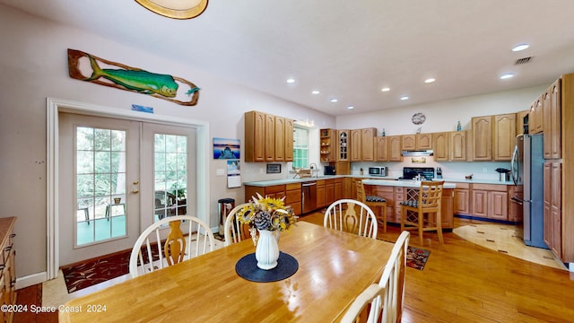 dining area featuring sink, light hardwood / wood-style floors, and french doors