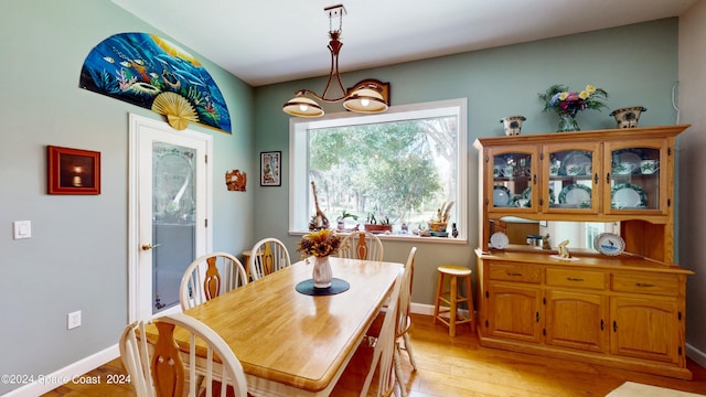 dining room with light hardwood / wood-style floors and a notable chandelier