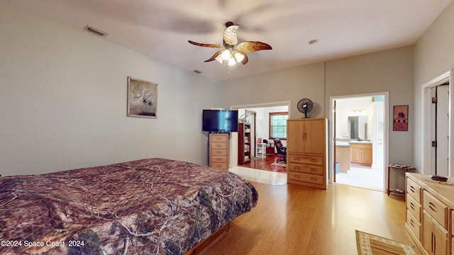 bedroom with light hardwood / wood-style flooring, ceiling fan, and ensuite bath