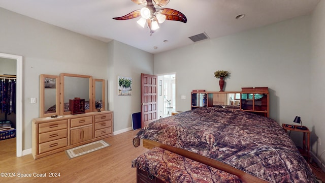 bedroom featuring ceiling fan, a walk in closet, a closet, and light hardwood / wood-style flooring