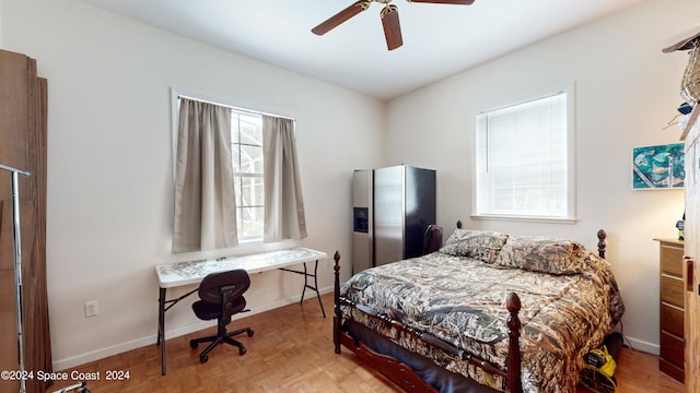 bedroom featuring ceiling fan, light parquet flooring, and multiple windows