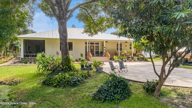 rear view of property featuring a lawn and a sunroom