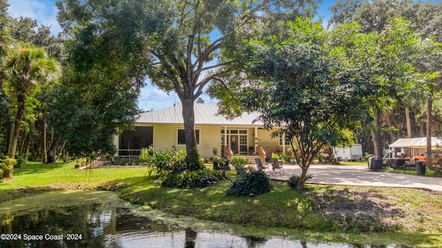 view of front of house with a front lawn and a water view