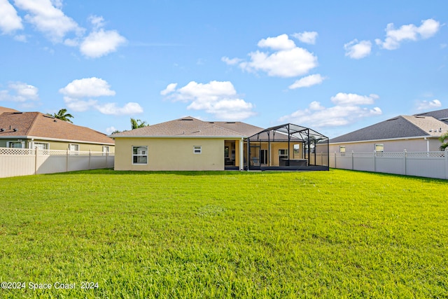 back of property with a lanai and a yard