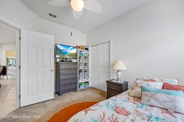 bedroom with ceiling fan, light carpet, and a closet