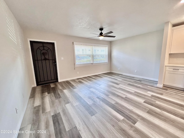 interior space with light hardwood / wood-style flooring, ceiling fan, and a textured ceiling