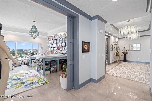 interior space featuring a textured ceiling, crown molding, and a notable chandelier