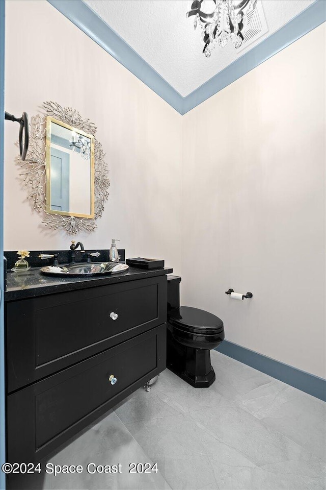 bathroom featuring vanity, toilet, and a textured ceiling