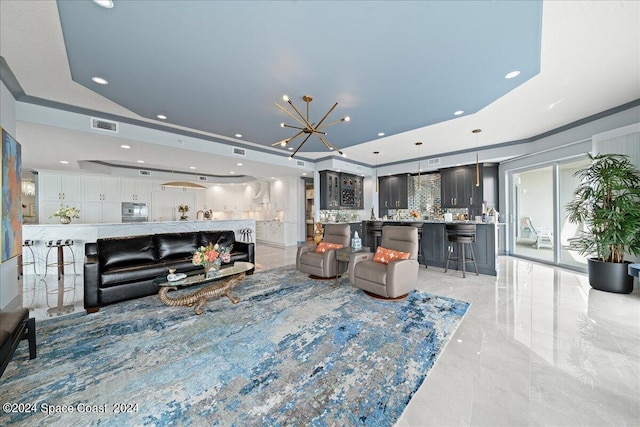 living room with an inviting chandelier and a tray ceiling