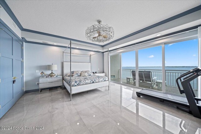 bedroom featuring a water view, a textured ceiling, and crown molding