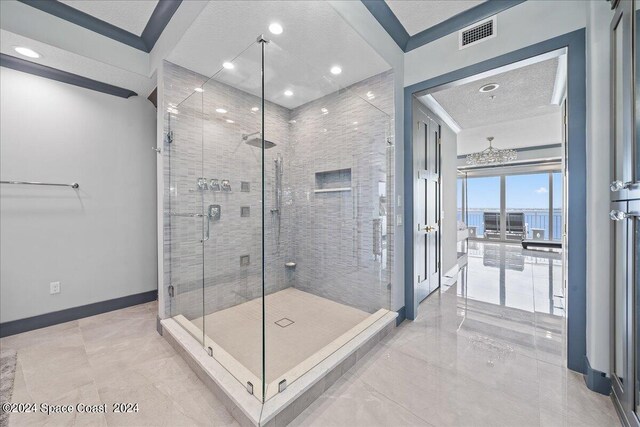 bathroom featuring a textured ceiling and a shower with door