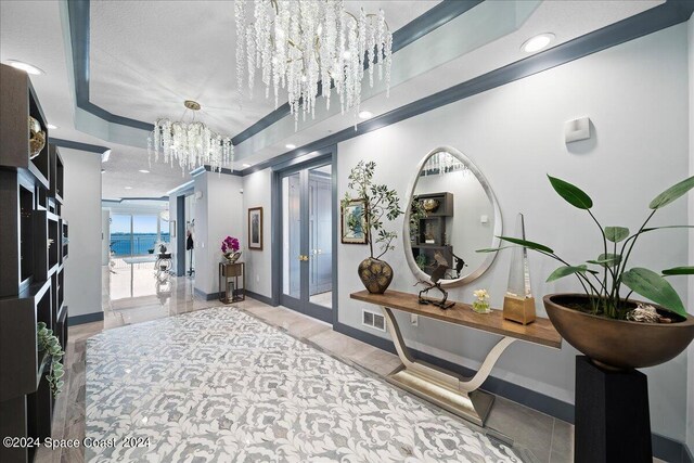 interior space with a textured ceiling, french doors, and a notable chandelier