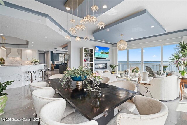 dining room with a fireplace and a tray ceiling