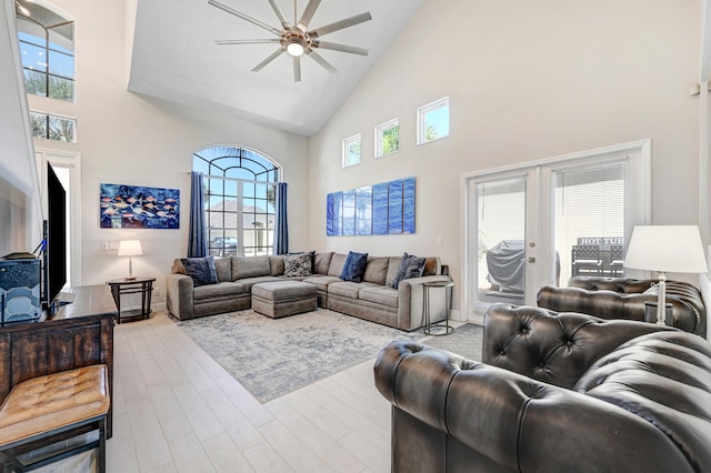 living room featuring ceiling fan, french doors, light hardwood / wood-style flooring, and high vaulted ceiling