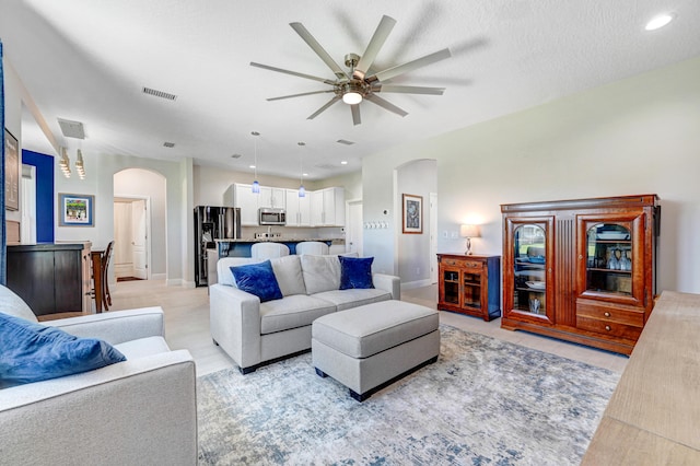 living room featuring a textured ceiling and ceiling fan