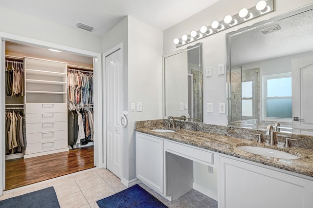 bathroom featuring hardwood / wood-style floors, vanity, a textured ceiling, and a shower with shower door