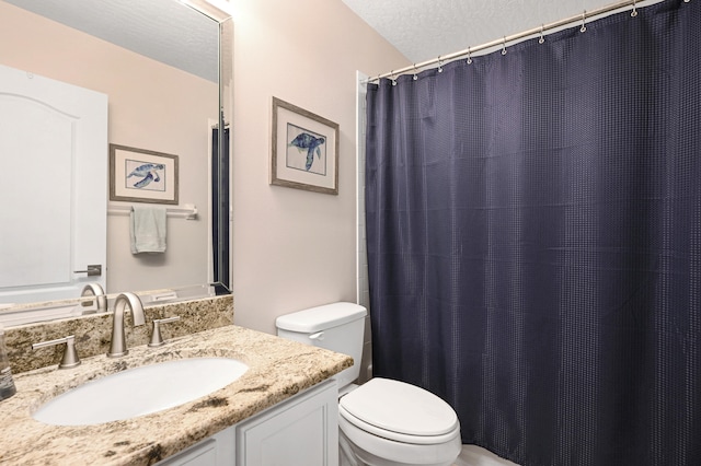 bathroom with vanity, a textured ceiling, and toilet