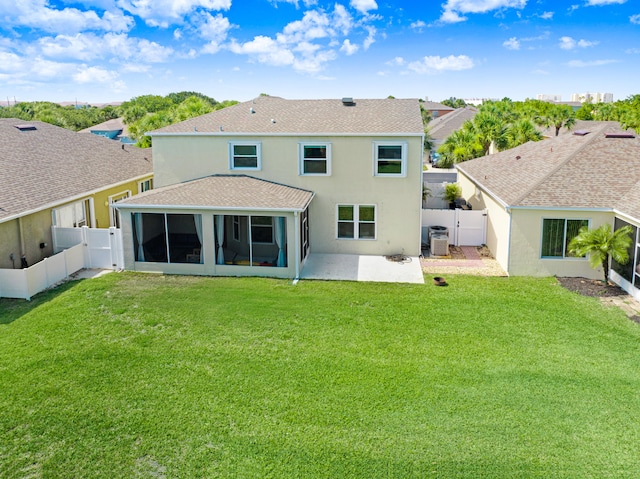 rear view of property featuring a sunroom, a patio, and a yard